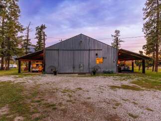 Discover this stunning property featuring a large metal barn with expansive sliding doors, perfect for storage or a workshop.