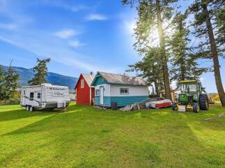 Discover this charming rural property featuring a spacious Wildwood travel trailer, perfect for guests or a cozy getaway.