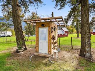 Discover this charming rustic outhouse, perfect for a unique addition to your property.