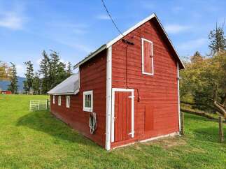 Nestled in a picturesque rural setting, this charming red barn offers a classic countryside aesthetic.