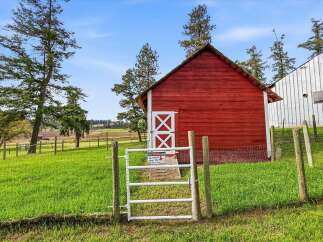 Discover rural charm with this picturesque property featuring a classic red barn and adjacent white metal building, perfect for agricultural pursuits or storage.