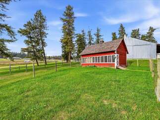 Discover rustic charm with this picturesque red barn, perfect for a hobby farm or equestrian enthusiast.