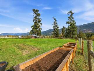 Cultivate your green thumb in this spacious backyard featuring two raised garden beds, perfect for growing your own vegetables and herbs.