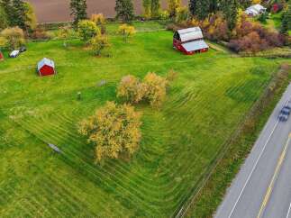 Discover this charming rural property featuring a classic red barn and a smaller red outbuilding, perfect for agricultural pursuits or storage.