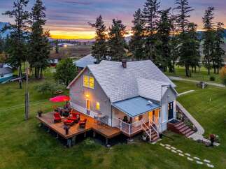 Experience serene country living in this charming home, featuring a spacious wooden deck perfect for outdoor entertaining.