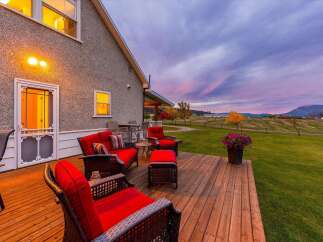 Enjoy breathtaking sunset views from this expansive wooden deck, perfect for outdoor entertaining.