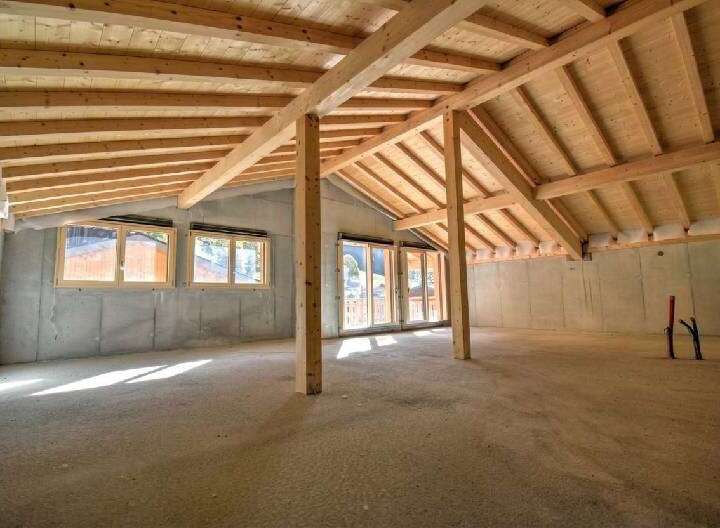 Discover the potential of this unfinished attic space, featuring exposed wooden beams and a vaulted ceiling that create a warm, rustic ambiance.