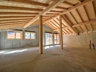 Discover the potential of this unfinished attic space, featuring exposed wooden beams and a vaulted ceiling that create a warm, rustic ambiance.