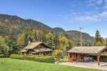 Nestled amidst the vibrant autumn foliage and majestic mountains, this charming wooden chalet offers a serene escape.