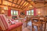 Experience rustic charm in this cozy living room, featuring exposed wooden beams and warm wood-paneled walls.