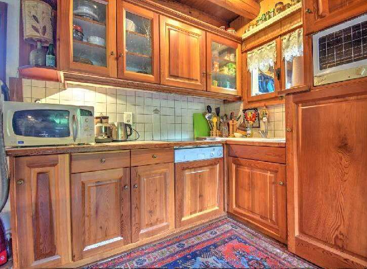 Step into this charming kitchen, featuring warm wooden cabinetry and a tiled backsplash.
