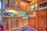 Step into this charming kitchen, featuring warm wooden cabinetry and a tiled backsplash.