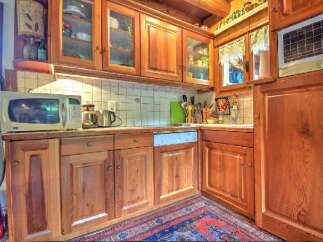 Step into this charming kitchen, featuring warm wooden cabinetry and a tiled backsplash.