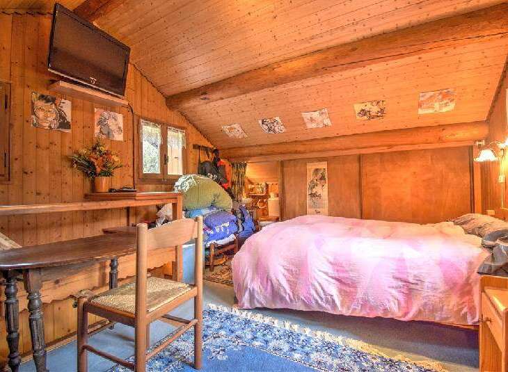Experience rustic charm in this cozy wooden cabin bedroom.