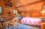 Experience rustic charm in this cozy wooden cabin bedroom.
