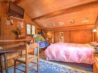 Experience rustic charm in this cozy wooden cabin bedroom.