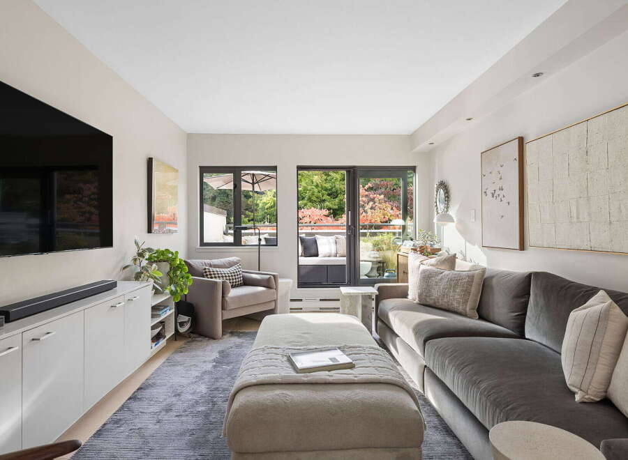 Step into this inviting living room, bathed in natural light and featuring a large sectional sofa perfect for relaxation.
