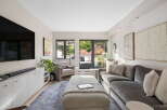 Step into this inviting living room, bathed in natural light and featuring a large sectional sofa perfect for relaxation.