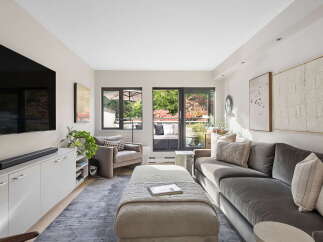 Step into this inviting living room, bathed in natural light and featuring a large sectional sofa perfect for relaxation.