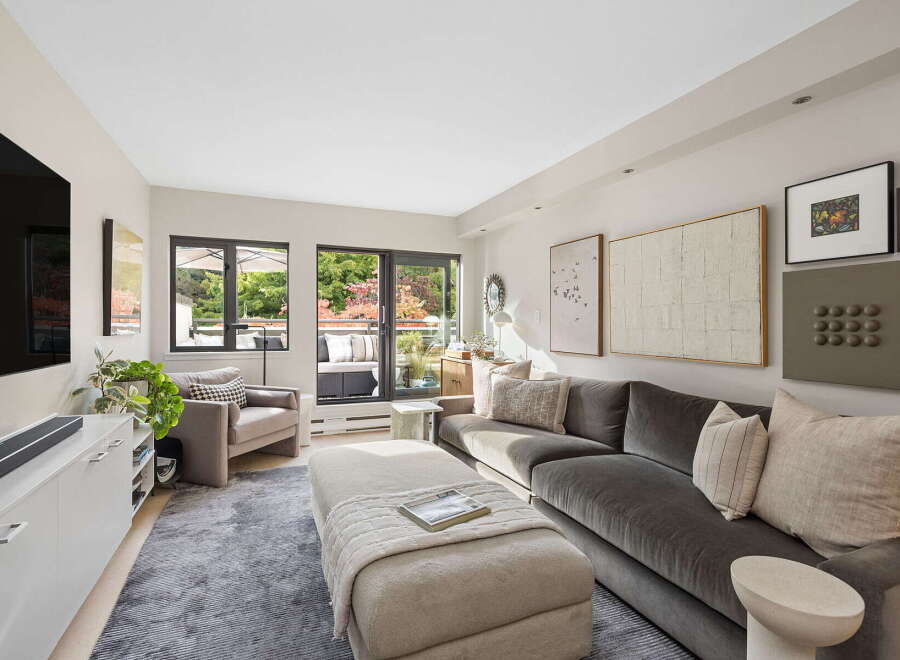 Step into this inviting living room, bathed in natural light from expansive windows and a glass door leading to a private balcony.