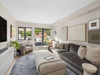 Step into this inviting living room, bathed in natural light from expansive windows and a glass door leading to a private balcony.