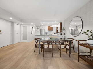 Step into this beautifully appointed dining area, featuring a sleek glass-top dining table with modern wooden chairs, perfect for intimate gatherings.