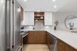 Experience modern living in this sleek kitchen, featuring high-gloss white cabinetry contrasted with warm walnut lower cabinets.