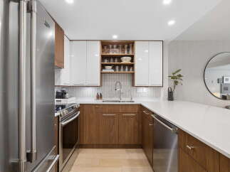 Experience modern living in this sleek kitchen, featuring high-gloss white cabinetry contrasted with warm walnut lower cabinets.