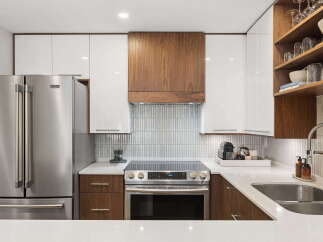 Experience modern luxury in this stunning kitchen, featuring sleek white cabinetry and warm wood accents.
