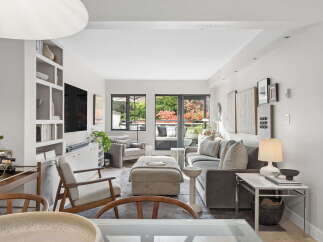 Step into this beautifully appointed living room, featuring a plush grey sectional sofa and a comfortable ottoman, perfect for relaxing.