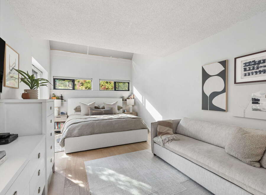 This modern bedroom offers a serene retreat with its minimalist design and abundant natural light.