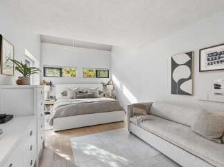 This modern bedroom offers a serene retreat with its minimalist design and abundant natural light.