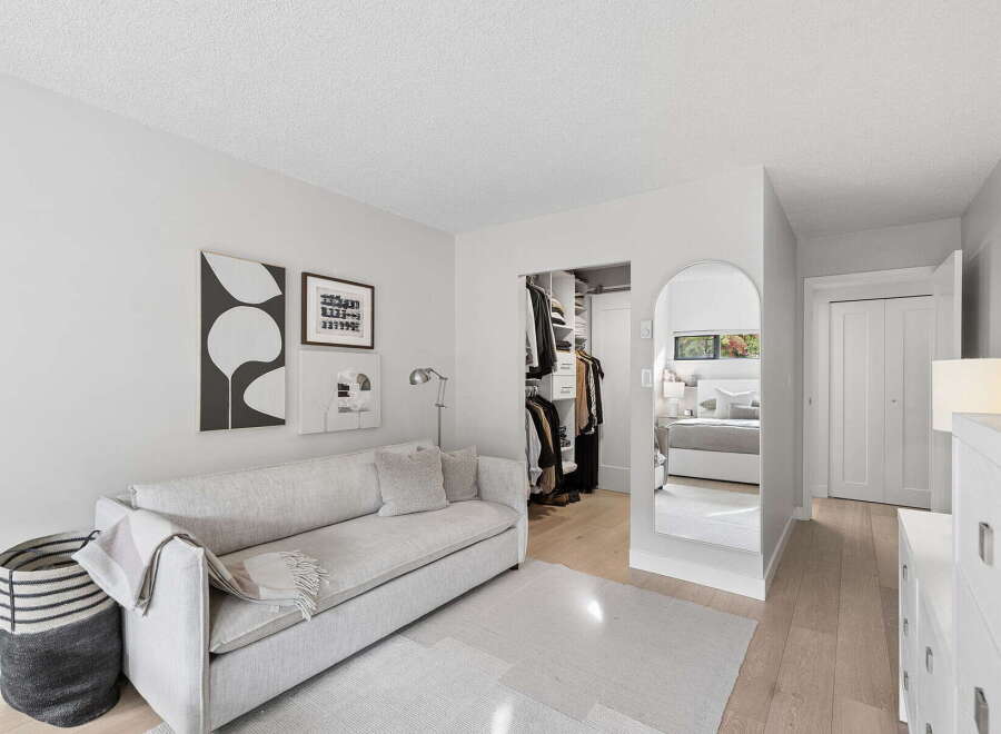 Step into a serene living space featuring a comfortable sofa adorned with plush pillows and a cozy throw blanket.