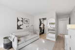 Step into a serene living space featuring a comfortable sofa adorned with plush pillows and a cozy throw blanket.