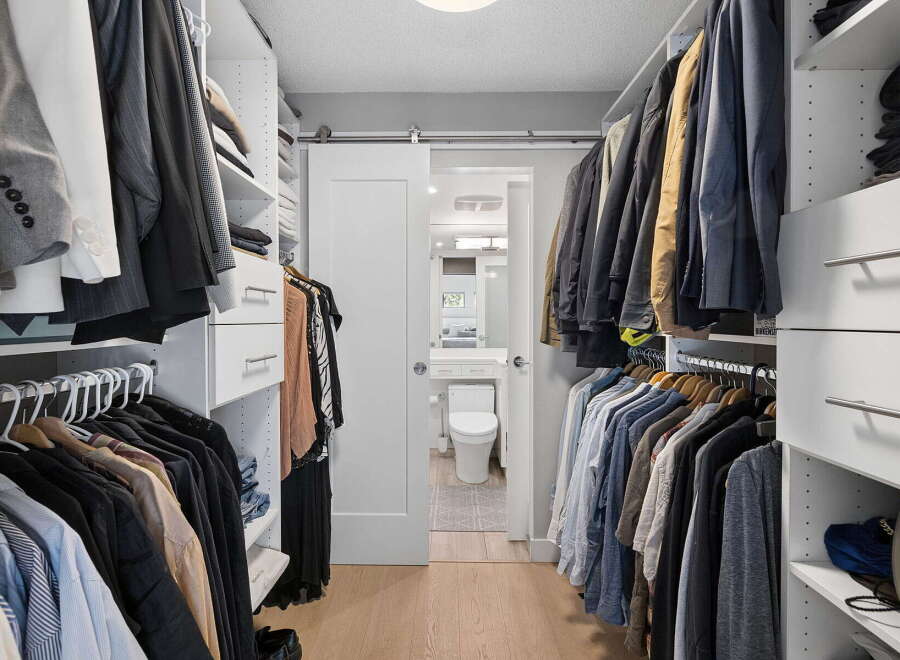 Step into this spacious walk-in closet, meticulously organized with ample shelving and hanging space for your wardrobe.