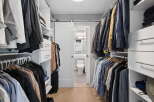 Step into this spacious walk-in closet, meticulously organized with ample shelving and hanging space for your wardrobe.