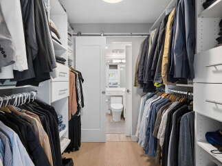 Step into this spacious walk-in closet, meticulously organized with ample shelving and hanging space for your wardrobe.
