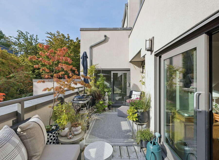 Enjoy outdoor living on this charming balcony, complete with a grill and comfortable seating.