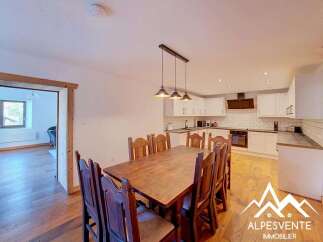 This charming dining area features a rustic wooden table surrounded by sturdy wooden chairs, perfect for family meals.