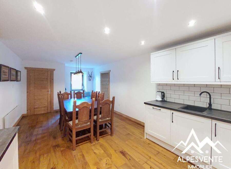 This spacious dining and kitchen area features a large wooden dining table with chairs, perfect for family meals.