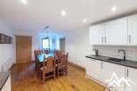 This spacious dining and kitchen area features a large wooden dining table with chairs, perfect for family meals.