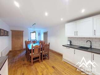 This spacious dining and kitchen area features a large wooden dining table with chairs, perfect for family meals.