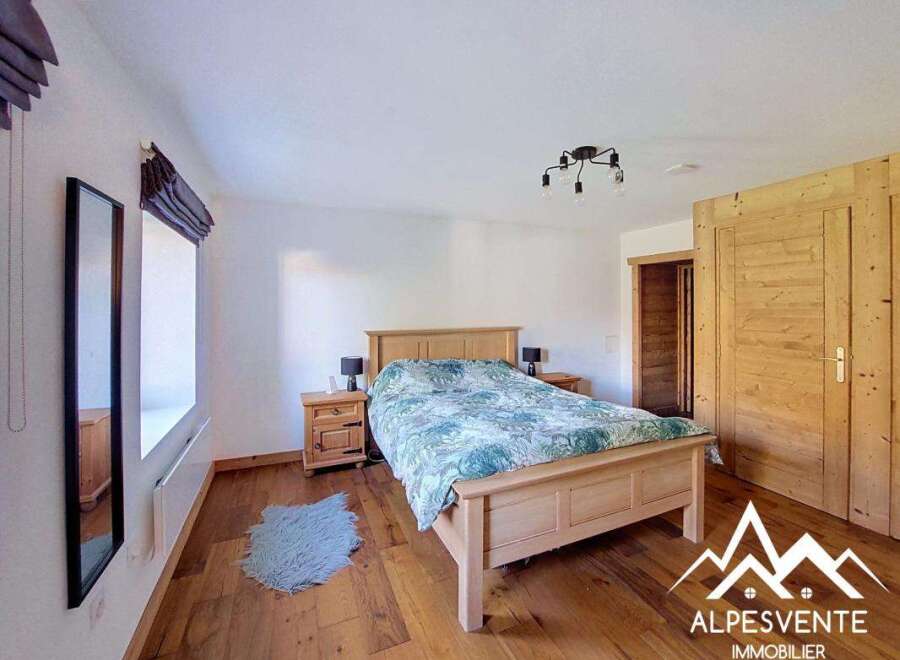This charming bedroom features a cozy wooden bed with a patterned duvet, complemented by matching bedside tables and lamps.