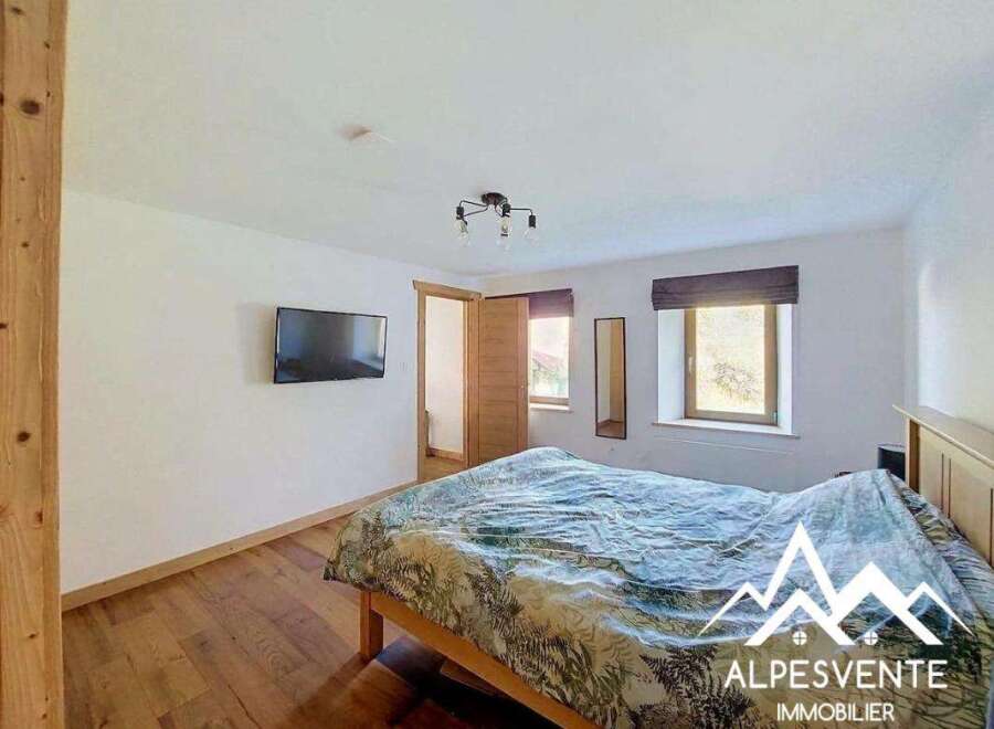 This charming bedroom features a comfortable bed with a nature-inspired duvet, perfect for a restful night's sleep.
