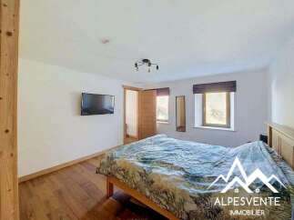 This charming bedroom features a comfortable bed with a nature-inspired duvet, perfect for a restful night's sleep.