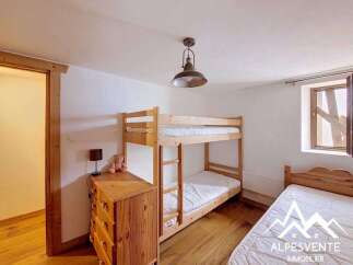 This charming bedroom features a space-saving bunk bed, perfect for families or accommodating guests.