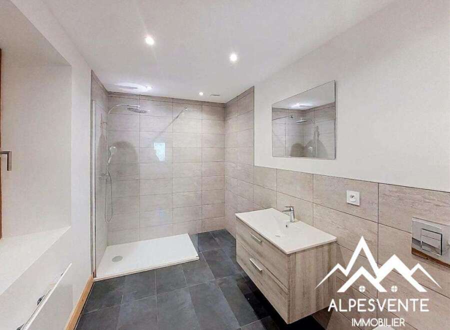 This modern bathroom features a spacious walk-in shower with sleek tilework and a rainfall showerhead, perfect for a relaxing experience.