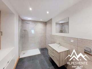 This modern bathroom features a spacious walk-in shower with sleek tilework and a rainfall showerhead, perfect for a relaxing experience.