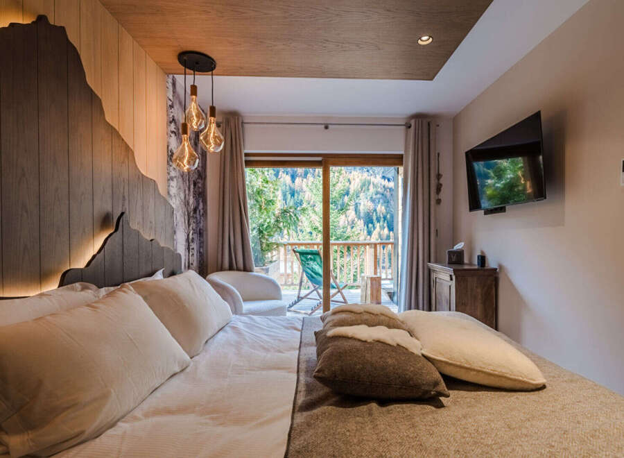 Experience ultimate comfort in this luxurious bedroom, featuring a king-size bed with plush pillows and a cozy duvet.