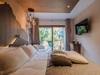 Experience ultimate comfort in this luxurious bedroom, featuring a king-size bed with plush pillows and a cozy duvet.